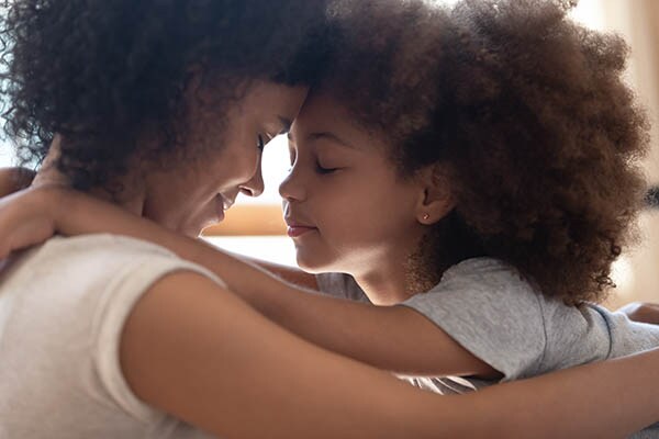 Close-up image of a mother and daughter hugging.